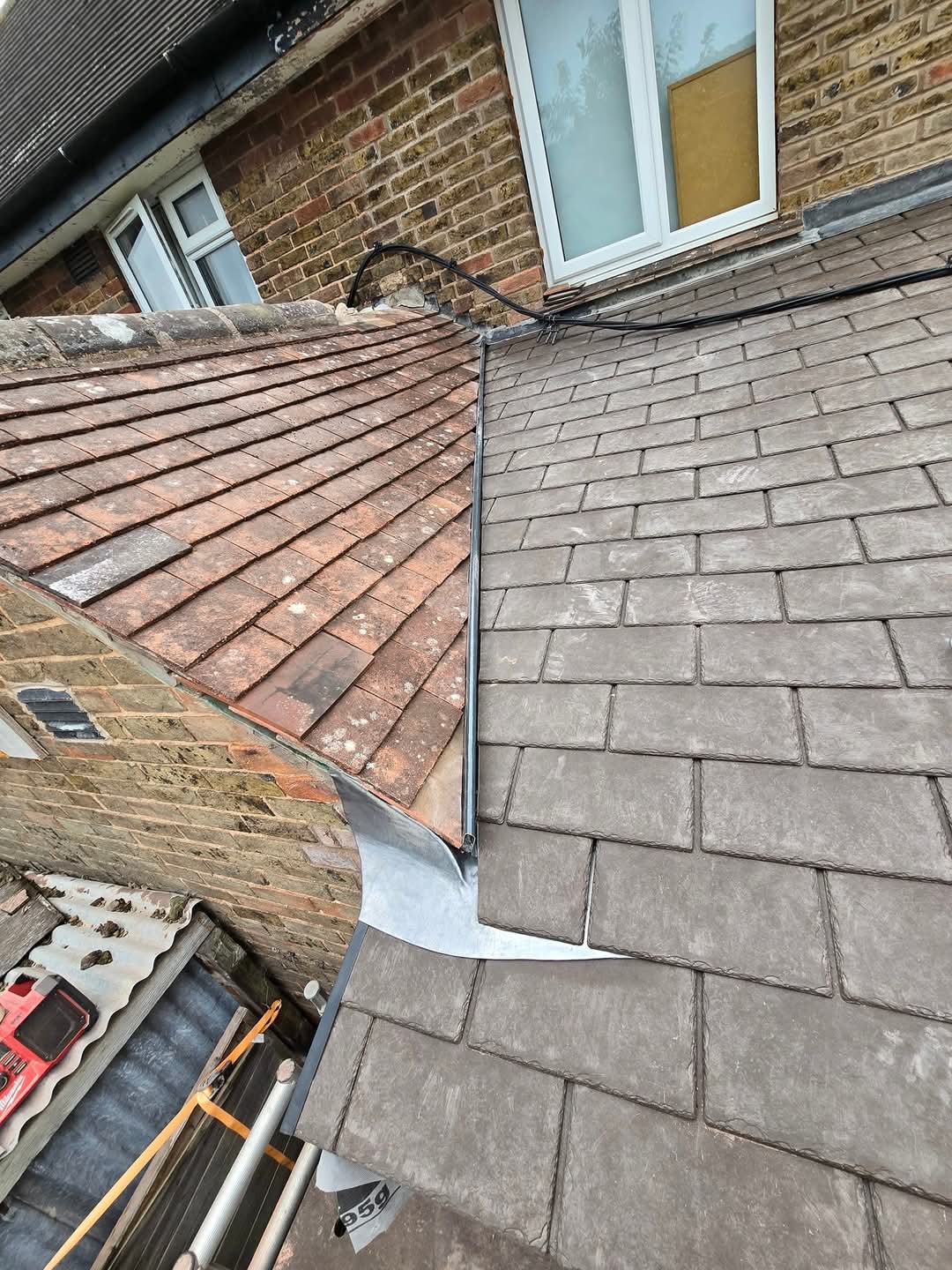 Lead flashing dressed into GRP valley between tile and slate